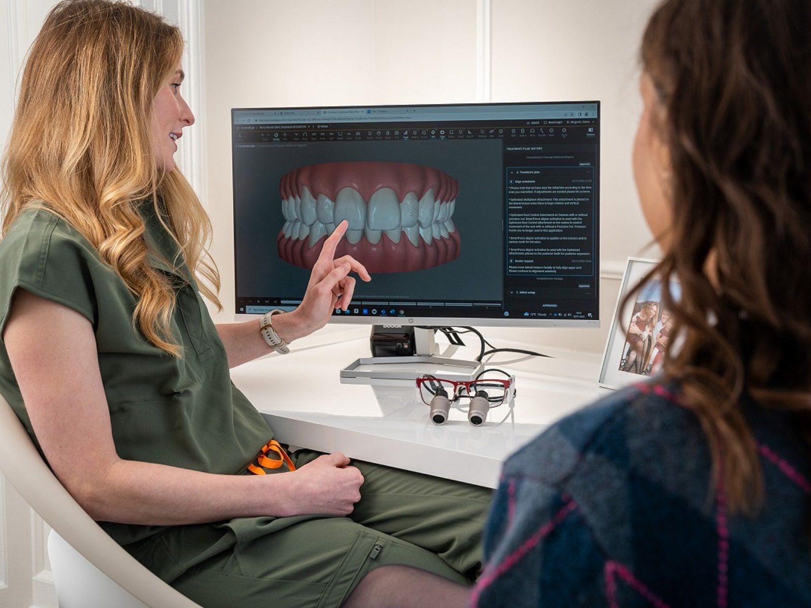 A dentist showing a digital smile design on a monitor