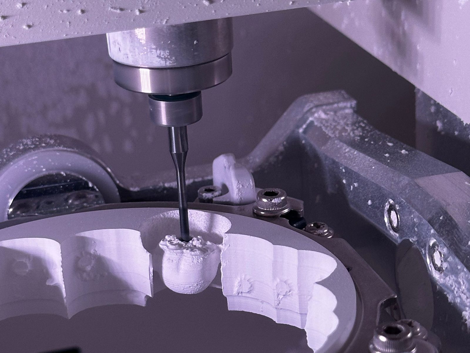 A milling machine cutting a crown from a ceramic block