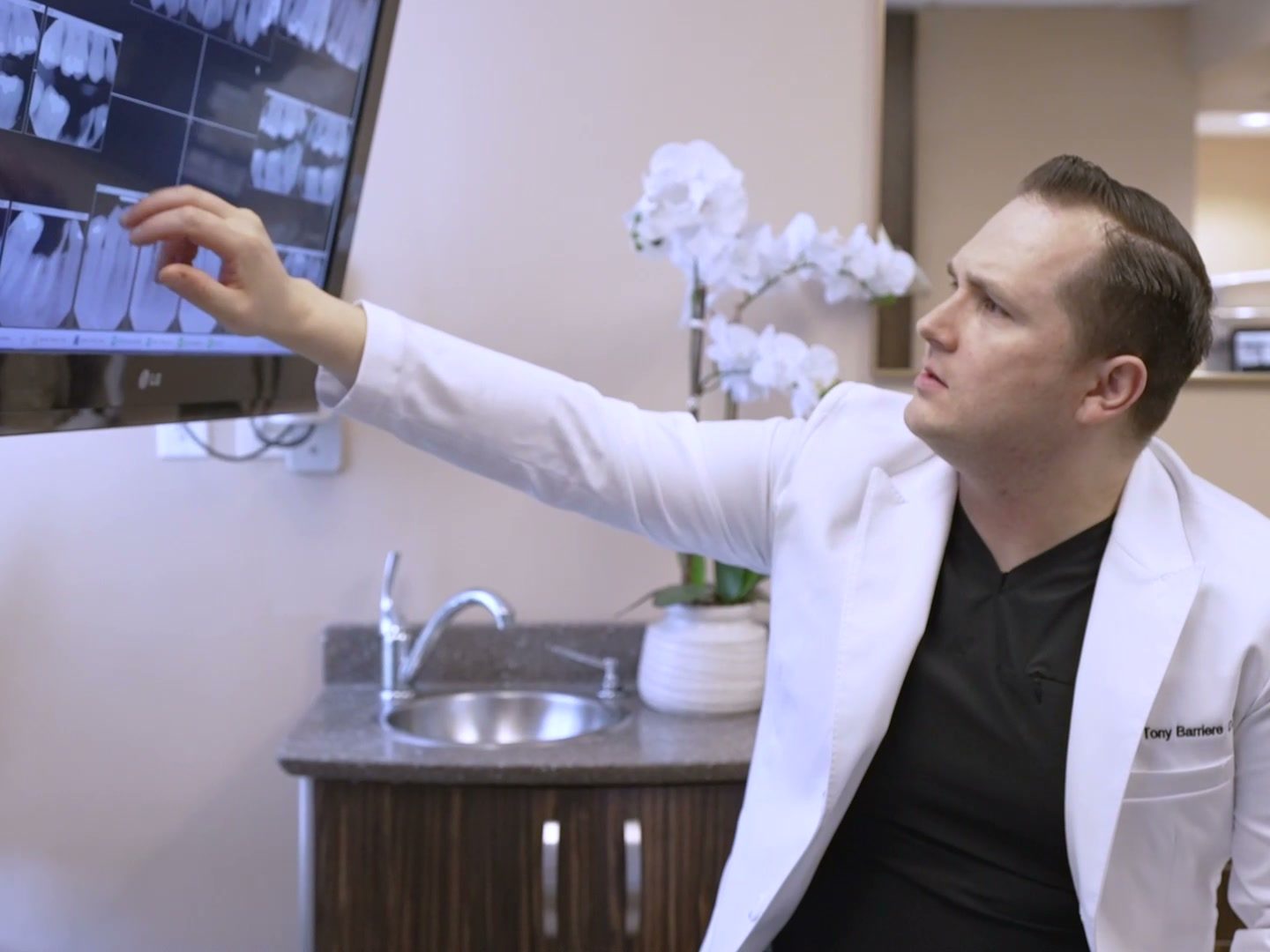 Dr. Tony Barriere reviewing a patient's scans on screen to plan implant treatment