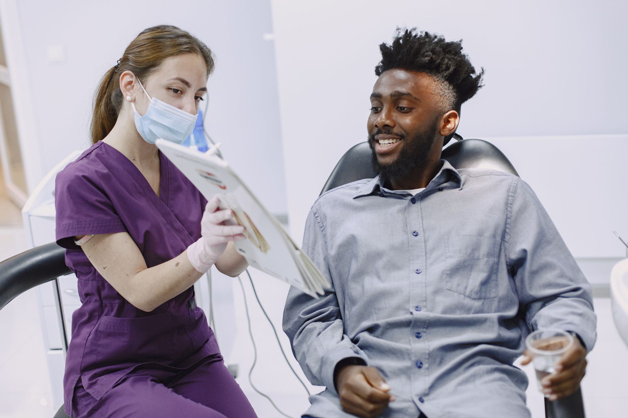 A smiling man talking with a dental team member about his smile