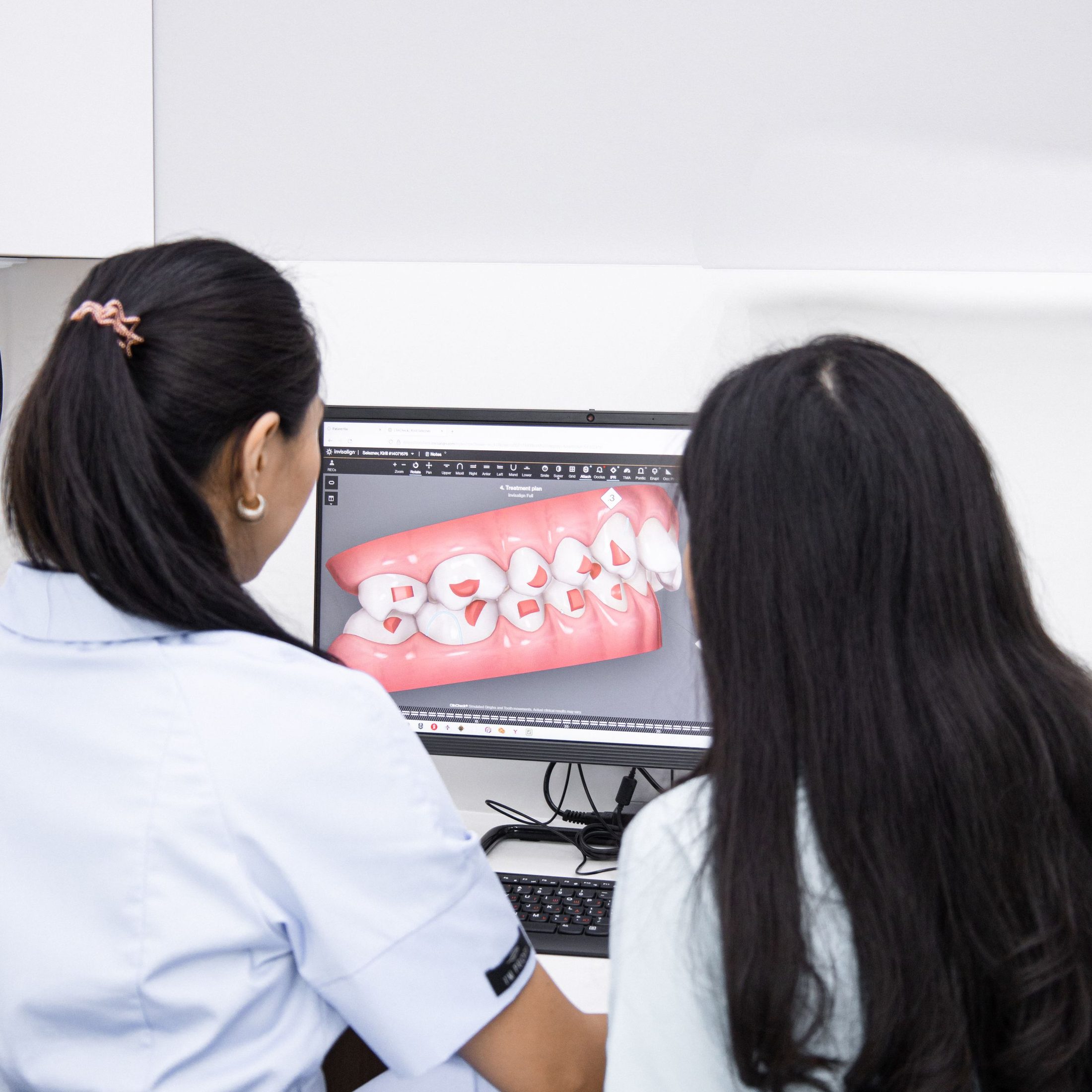 A dentist and a patient looking at a 3D smile design on screen