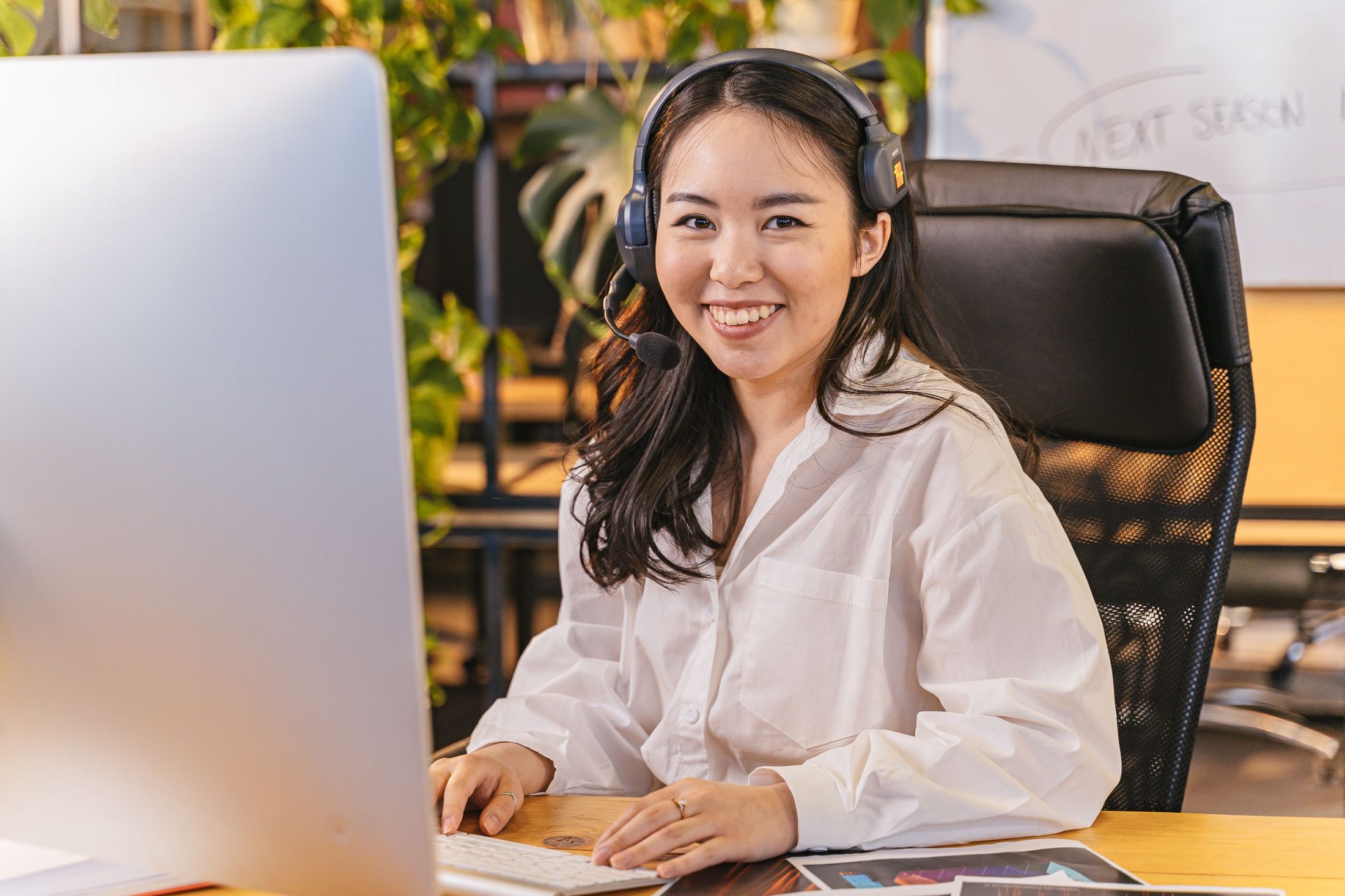 A smiling team member answering calls at her desk