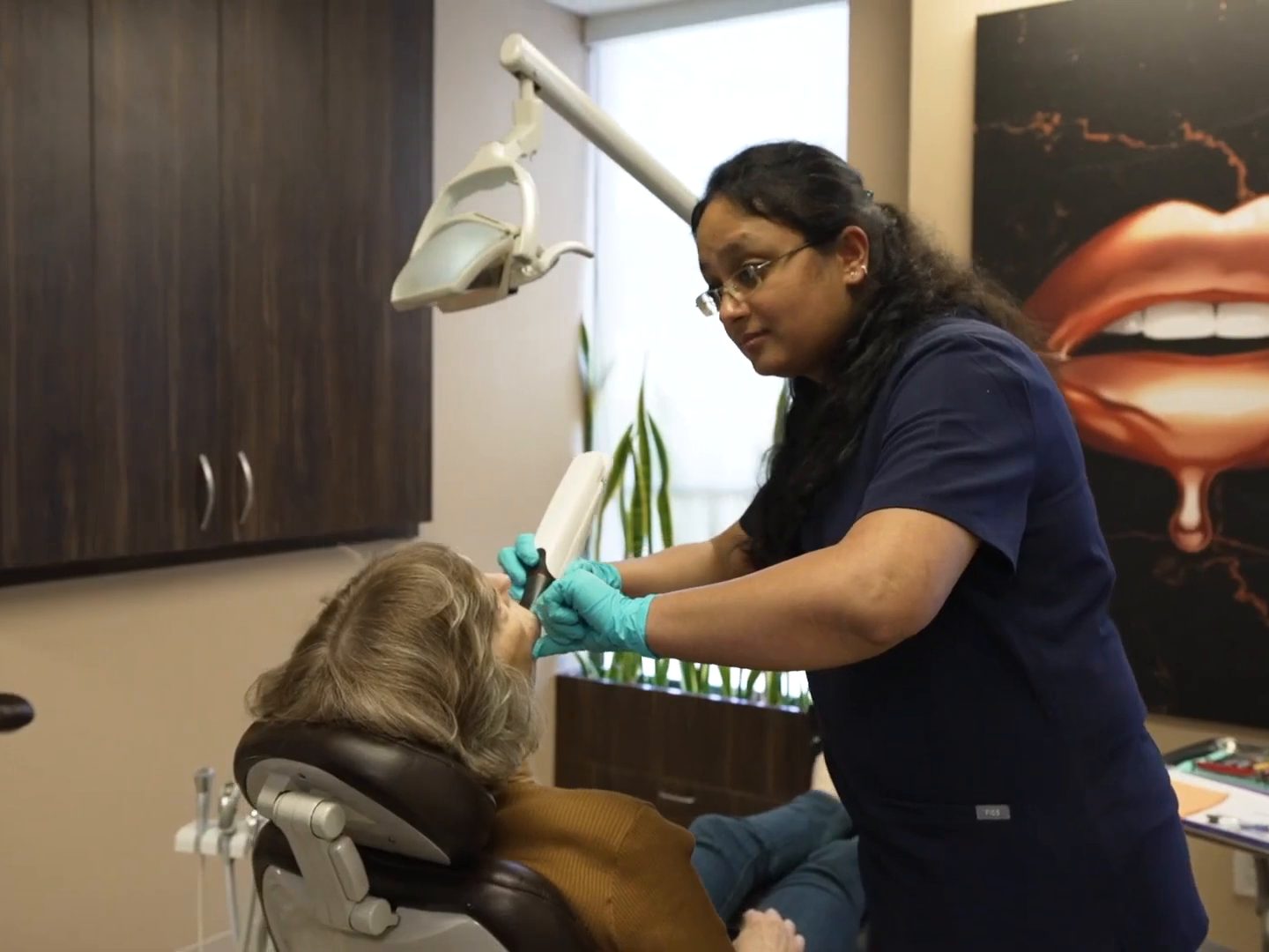 A West LA Implants assistant scanning a patient's teeth with an intraoral scanner