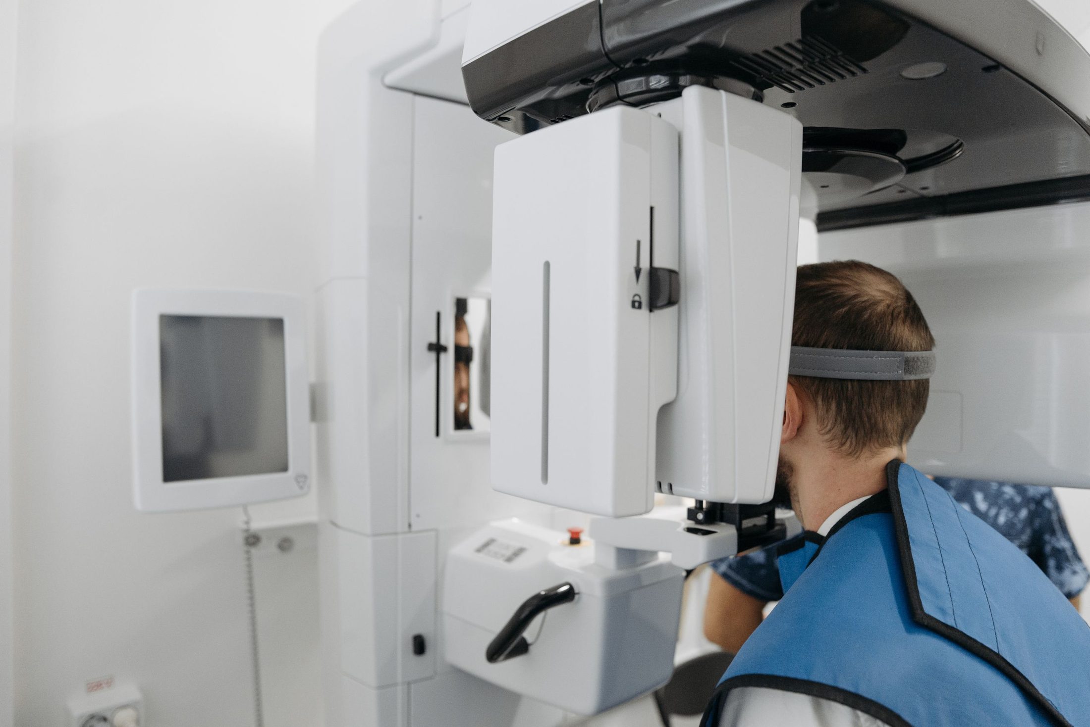A patient standing in a cone-beam CT scanner