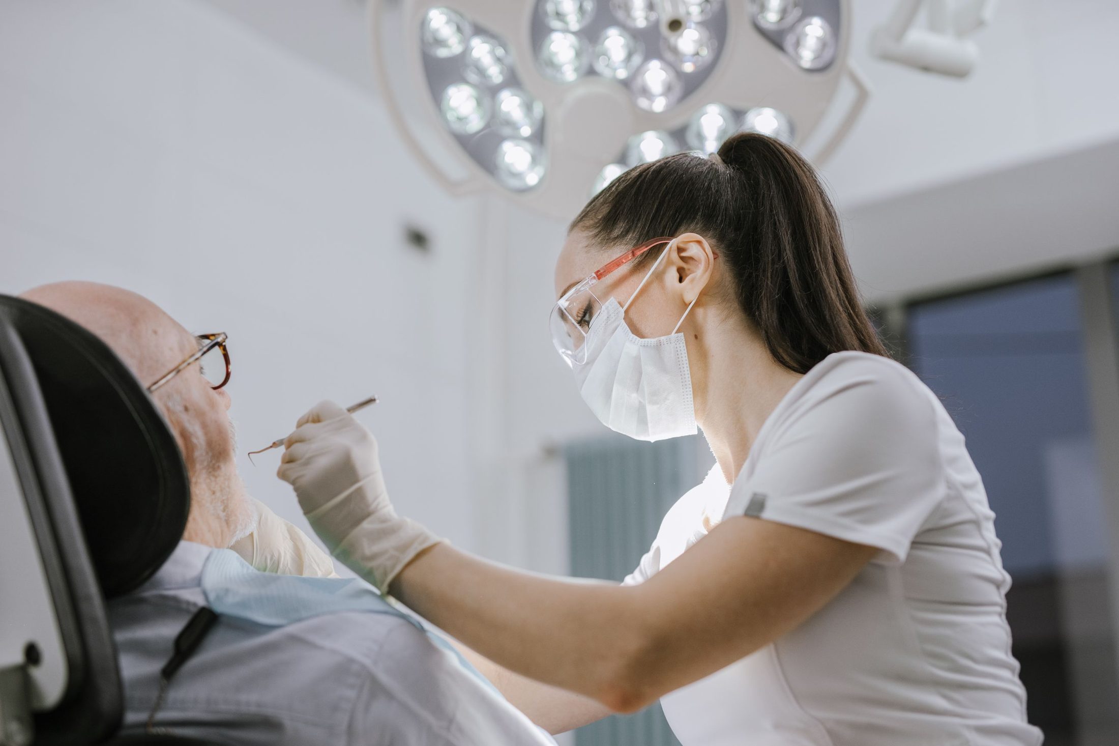 A hygienist treating a relaxed older patient